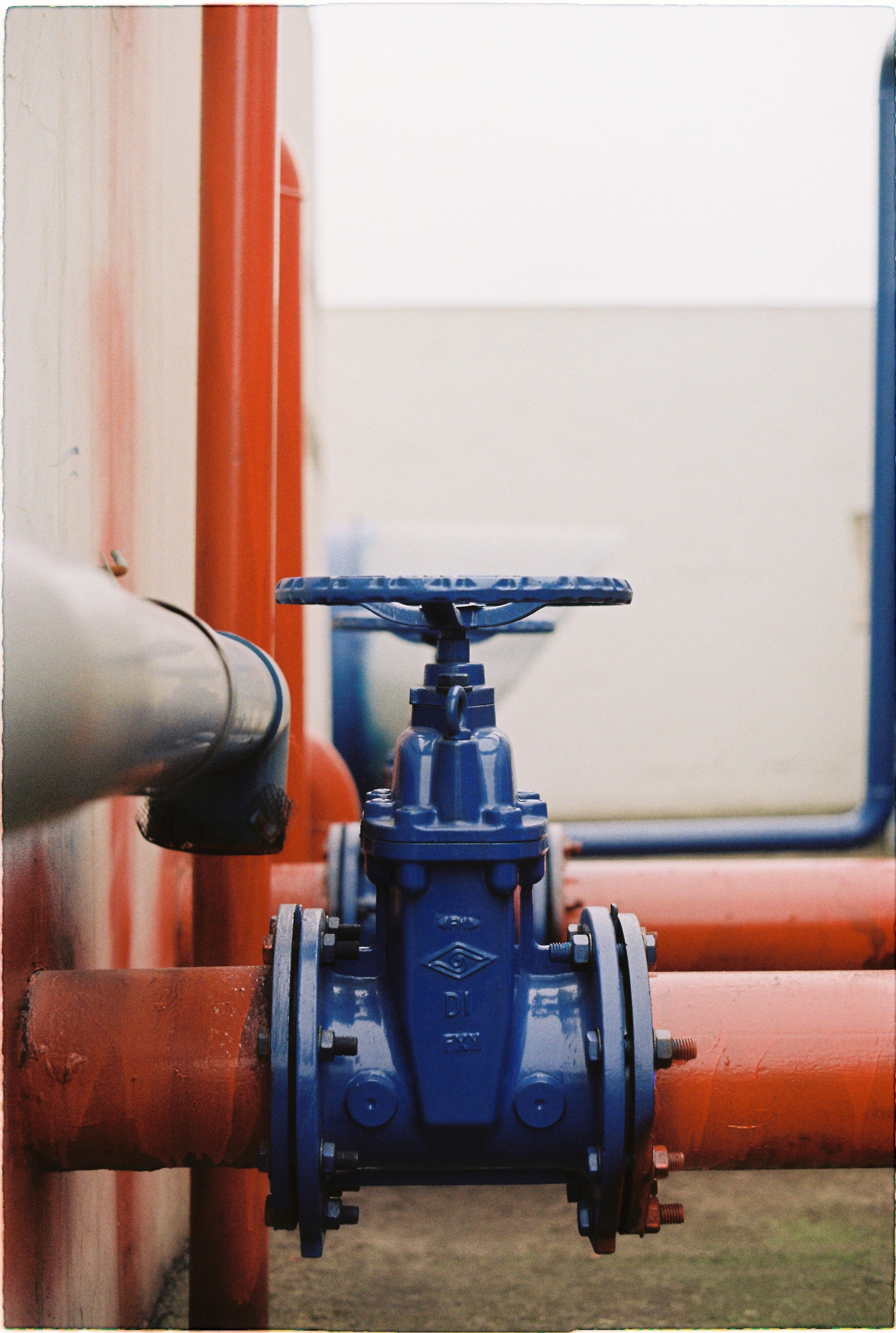 Blue gate valve and bolted flanges on above-ground mechanical piping